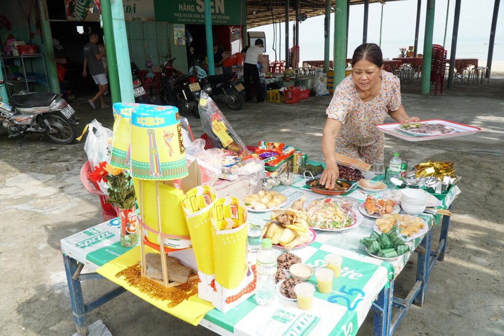 a woman adding more foods to the altar
