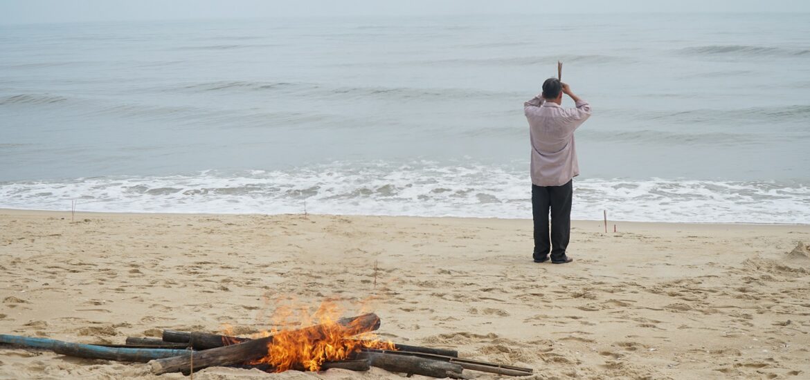 A pile of fire and a man on the beach