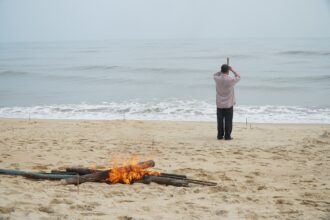A pile of fire and a man on the beach