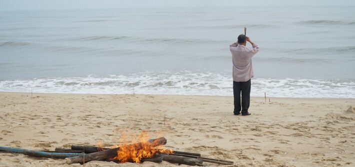 A pile of fire and a man on the beach